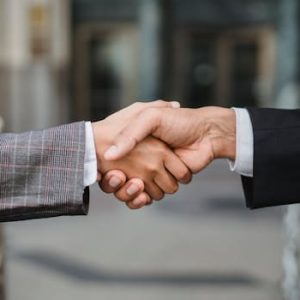 A close-up of two businesspeople shaking hands, symbolizing cooperation and partnership.